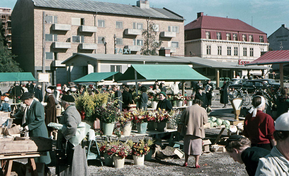 Marknadsstånd med blommor på torg.